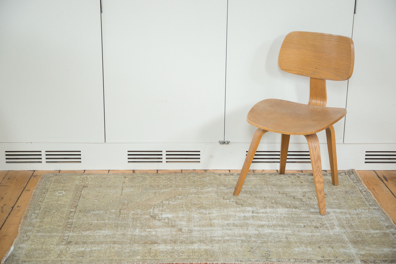 Distressed vintage Oushak rug in soft earth tones, highlighting its faded texture.